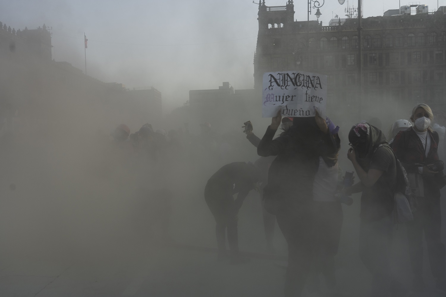 Manifestantes se resguardan durante una la protesta el 8 de marzo del 2022. Las autoridades rociaron de un polvo de extintor y un agente químico lo que generaba ardor intenso en nariz, ojos y boca | Foto: Mónica González